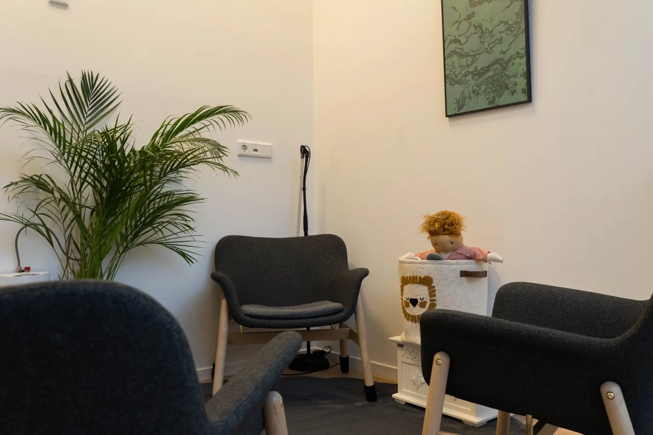 Therapieraum mit Sesseln, Palme und Spielkorb mit Puppe