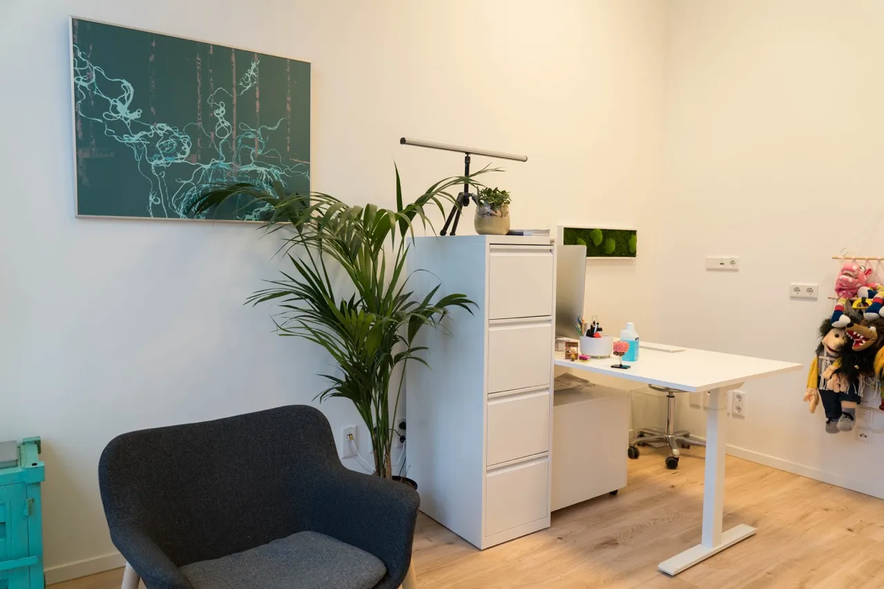 Arbeitsbereich mit Schreibtisch, Sessel und Wandbild