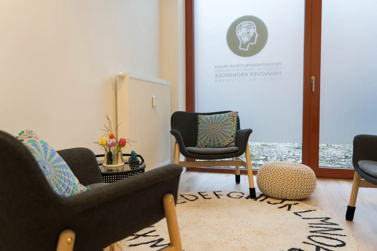 Sessel mit Kissen, Sitzpouf und Fenster mit Praxislogo