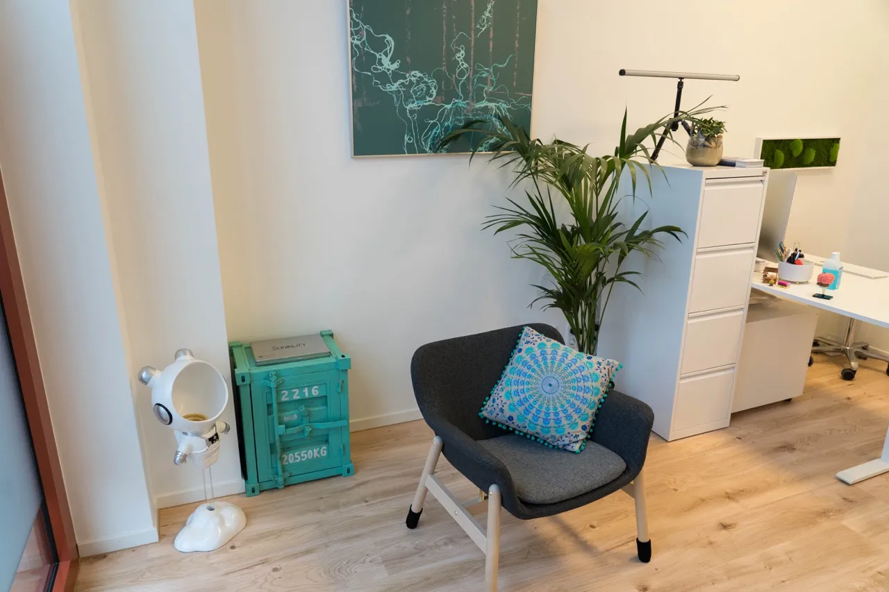 Sessel, Spielkiste und Schreibtisch im Therapieraum